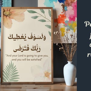 Pu&ograve; includere: Stampa incorniciata con calligrafia araba e traduzione inglese, con accenti floreali e di foglie. L'opera d'arte ha uno sfondo beige chiaro e una cornice in legno. Il testo recita: "And your Lord is going to give you, and you will be satisfied."
