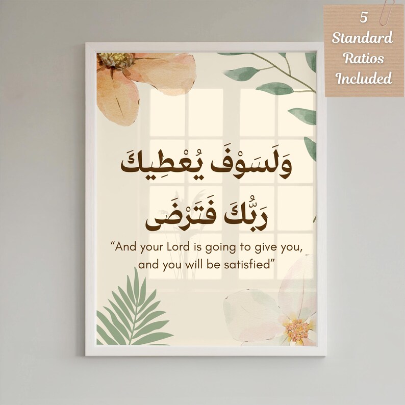 Pu&ograve; includere: Stampa incorniciata con calligrafia araba in inchiostro marrone e traduzione inglese. L'opera d'arte include motivi floreali e di foglie in colori tenui. La cornice bianca circonda il testo "And your Lord is going to give you, and you will be satisfied."