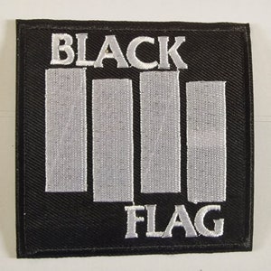 May include: Black and white embroidered patch with the words "Black Flag" and a series of vertical bars.