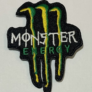 May include: Black and green embroidered patch featuring the Monster Energy logo. The logo shows a claw mark with three dripping claws and the words "Monster Energy" in white.