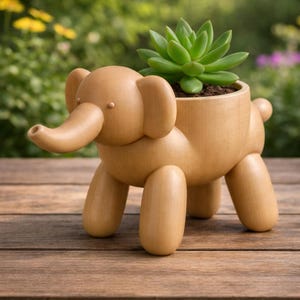 May include: A wooden elephant planter with a succulent plant. The light brown elephant has large ears, a trunk, and four legs. The succulent is green and sits in a pot on the elephant's back. The planter is on a wooden surface.