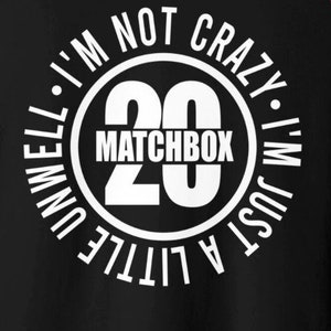 May include: Black baseball tee with white text that reads "I'M NOT CRAZY, I'M JUST A LITTLE UNWELL" around a white circle with "20 MATCHBOX" in the center. The sleeves are red.