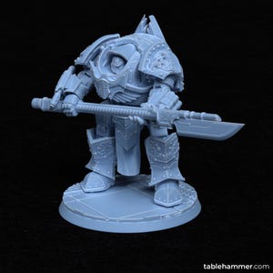 Puede incluir: Una miniatura de plástico gris de un robot guerrero sosteniendo una gran espada. El robot lleva una armadura con detalles intrincados y está de pie sobre una base circular.