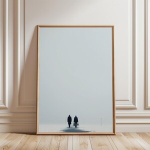 Könnte beinhalten: Gerahmter Kunstdruck mit zwei Figuren, die sich in einer minimalistischen, atmosphärischen Szene vom Betrachter entfernen. Das Kunstwerk hat einen hellblau-grauen Hintergrund und einen Holzrahmen. Die Figuren sind silhouettenhaft dargestellt.