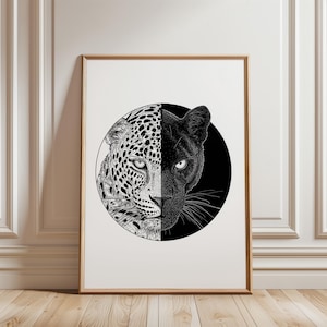 May include: A framed art print featuring a circular illustration of a big cat face split down the middle. The left side shows a spotted leopard in black ink on a white background, while the right side shows a black panther on a black background.