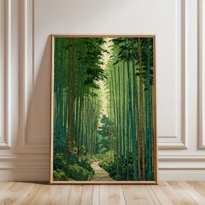 Puede incluir: Una lámina de arte vertical enmarcada que representa un denso bosque de bambú con tallos verdes altos y un estrecho camino de piedra que serpentea por el centro. La escena presenta varios tonos de follaje verde y un cielo amarillo pálido.