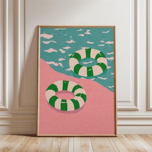 Könnte beinhalten: Ein rechteckiger Wandkunstdruck mit einer grafischen Illustration von zwei gestreiften Schwimmringen in Grün und Creme. Ein Ring liegt auf einer einfarbigen rosa Fläche, während der andere in einem türkisfarbenen Gewässer mit hellrosa Wellenmuster schwimmt.