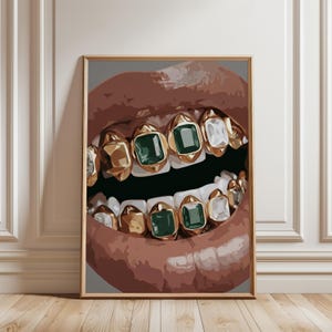 Può includere: Opera d'arte incorniciata con un primo piano di una bocca con denti d'oro. Alcuni denti hanno pietre preziose verde smeraldo e bianche. Le labbra sono di colore marrone rossiccio e lo sfondo è grigio neutro.