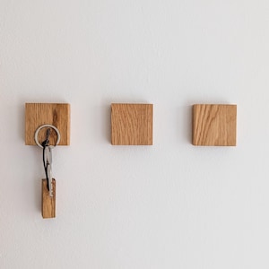 Minimalistischer Schlüsselhalter aus Eichenholz mit verborgenen Magneten, an der Wand montiert, hält Schlüssel ohne Haken