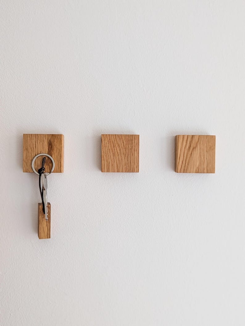 Minimalistischer Schlüsselhalter aus Eichenholz mit verborgenen Magneten, an der Wand montiert, hält Schlüssel ohne Haken