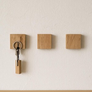 Eleganter Wand-Key Rack aus massiver Eiche mit unsichtbaren Magneten, Schlüssel befestigt via Metallring am Holzblock.