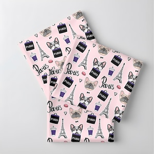 May include: Pink fabric with a repeating pattern of French bulldogs, Eiffel Towers, coffee cups, handbags, and the word "Paris". The design includes hearts and bow ties.