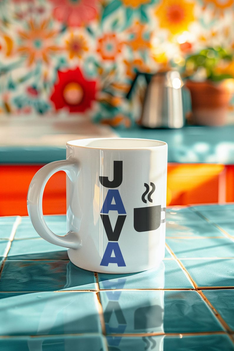Pu&ograve; includere: Tazza in ceramica bianca con la scritta "JAVA" in lettere nere e blu e una grafica di tazza di caff&egrave; nera. La tazza &egrave; su una superficie piastrellata blu, con uno sfondo floreale colorato.