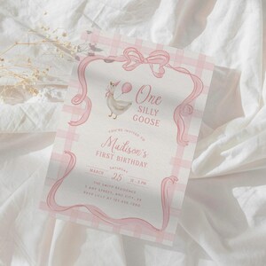 May include: A pink and white gingham patterned invitation with a watercolor illustration of a goose holding a balloon. The text reads "One Silly Goose" and "Madison's First Birthday". The invitation is framed with pink ribbons and a bow.