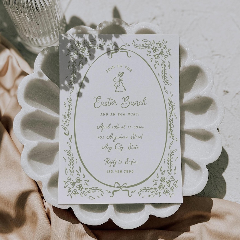 May include: A white card with a green floral border and a bunny illustration. The card reads "Join us for Easter Bunch and an egg hunt!" with details for the event: April 20th at 11:00am, 102 Anywhere Street, Any City, State. It also includes a reply to Sofia at 123.456.7890.