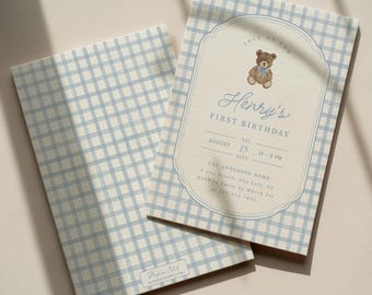 May include: A rectangular birthday invitation card featuring a light blue and white gingham pattern. The centre displays a brown teddy bear illustration, the text Henry's FIRST BIRTHDAY, and event details including date, time, and location.