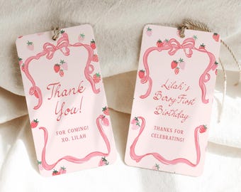 May include: Two rectangular light pink gift tags with rounded corners, featuring a pink ribbon border, strawberry illustrations, and text. One tag reads Thank You! FOR COMING! XO. LILAH. The other reads Lilah's Berry First Birthday THANKS FOR CELEBRATING!