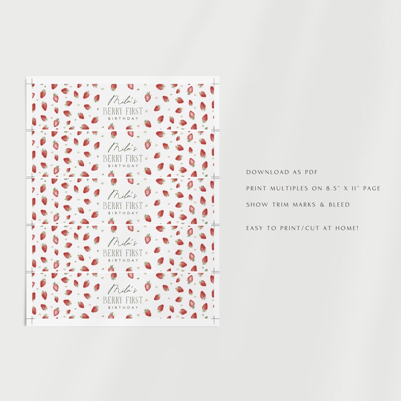 May include: A printable sheet featuring a strawberry design and the text "Mili's Berry First Birthday." The pattern includes red strawberries with green details on a white backdrop. Designed for printing on A4 paper, with trim marks and bleed.