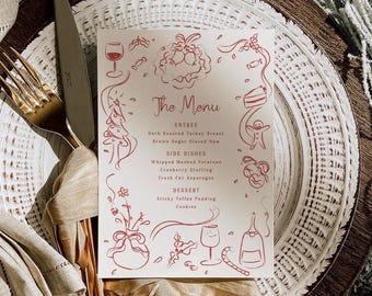 May include: A festive menu card with red illustrations and text, including a wine glass, Christmas tree, and gingerbread man. The menu lists entree, side dishes, and dessert options. The card is placed on a white plate with a gold fork and knife.
