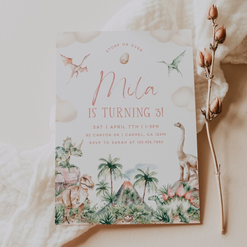 May include: A dinosaur-themed birthday party invitation with a pink and white color scheme. The invitation features a watercolor illustration of dinosaurs, a volcano, and palm trees. The text on the invitation reads "STOMP ON OVER Mila IS TURNING 3! SAT | APRIL 7TH | 1-3PM 82 CANYON DR | CARMEL, CA 12345 RSVP TO SARAH AT 123.456.7890"