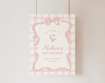 Puede incluir: Un letrero de cumpleaños rectangular con un fondo de cuadros rosa claro y blanco. El centro muestra un panel color crema enmarcado por cintas rosas y un lazo, con una ilustración de un ganso y el texto Madison's FIRST BIRTHDAY.