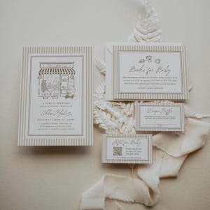 Könnte beinhalten: Ein Babyparty-Einladungsset mit einer Café-Illustration, einer Books for Baby-Karte, einer Diaper Raffle-Karte und einer Registrierungskarte mit QR-Code. Das Briefpapier hat einen beigen und weißen vertikalen Streifenrand und schwarzen Text.