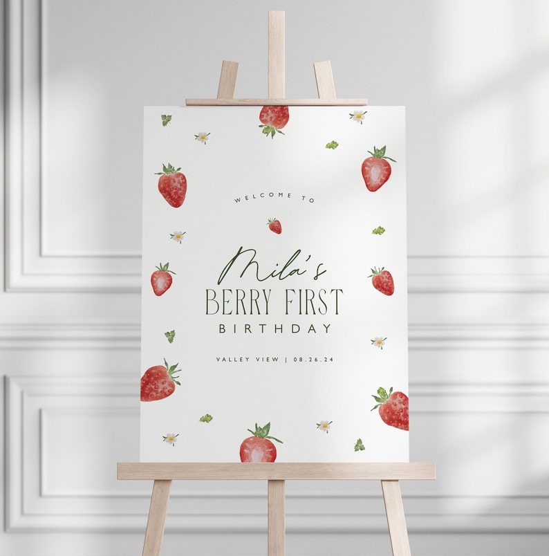 May include: A white sign on a wooden easel, decorated with watercolor strawberries and floral accents. The sign reads "Welcome to Mila's Berry First Birthday" with the date 08.26.24. A charming design for a birthday celebration.
