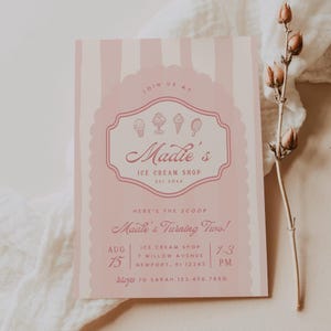 Puede incluir: Una invitaci&oacute;n a rayas rosa y blancas con un borde rosa festoneado. La invitaci&oacute;n es para una fiesta de cumplea&ntilde;os en "Madie's Ice Cream Shop" para un ni&ntilde;o que cumple dos a&ntilde;os. La invitaci&oacute;n incluye la fecha, la hora y la direcci&oacute;n de la fiesta.