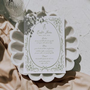 Pu&ograve; includere: Un biglietto bianco con un bordo verde e un design floreale. Il biglietto presenta un menu per un brunch di Pasqua con il titolo "Easter Menu" e la data "April 20th, 2023". Il menu include antipasti, piatto principale, dessert, caff&egrave; e t&egrave;.