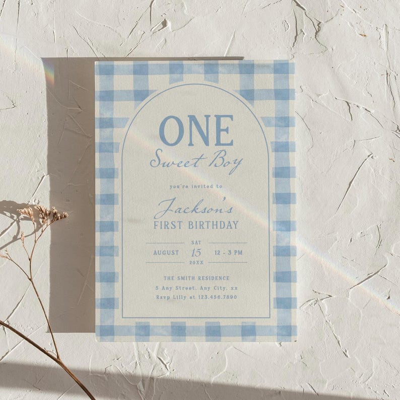 May include: A light blue and white gingham patterned invitation card. The card reads "ONE Sweet Boy" and "Jackson's FIRST BIRTHDAY" with the date, time, and location details. The design includes an arched frame.
