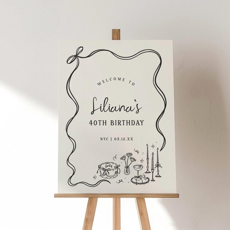 May include: A white sign on a wooden easel with black line art. The sign reads "Welcome to Liliana's 40th Birthday" with the city and date below. The bottom of the sign features illustrations of a cake, flowers, and candles.