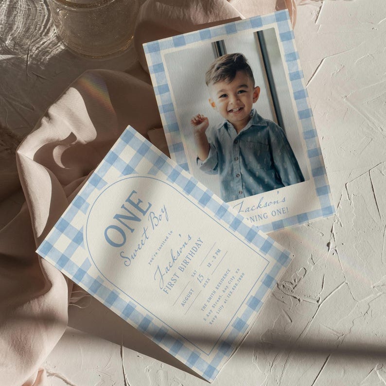 May include: Two invitations with a blue and white gingham border. One features a photo of a smiling child. The other says "ONE Sweet Boy" and "Jackson's FIRST BIRTHDAY" with the date and time. The invitations are on a white textured surface.