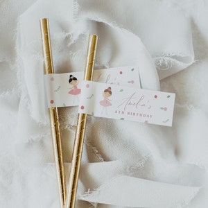 May include: Two gold straws with pink and green paper flags. The flags have a ballerina illustration and the text "Amelia's 4th Birthday".