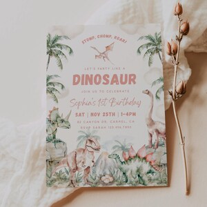 May include: A pink and green dinosaur-themed first birthday party invitation with a watercolour illustration of dinosaurs, palm trees, and eggs. The text reads "Stomp, Chomp, Roari Let's Party Like A Dinosaur Join Us To Celebrate Sophia's 1st Birthday Sat Nov 25th | 1-4pm 82 Canyon Dr. Carmel, CA RSVP Sarah 123.456.7890"