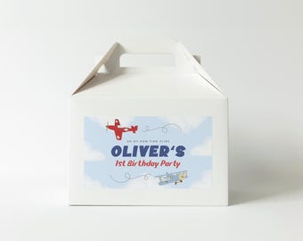 May include: White favor box with a blue and white sticker featuring a red airplane and a blue airplane. The sticker says "Oh my how time flies Oliver's 1st Birthday Party."