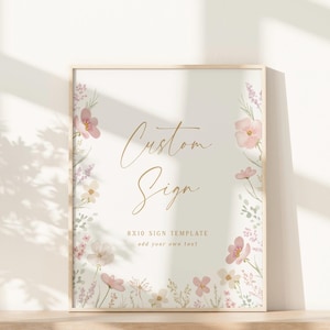 May include: A framed sign with a light beige background, featuring the words "Custom Sign" in elegant gold script. The sign is adorned with watercolor-style pink and white flowers and greenery. The text "8x10 Sign Template" is also included.