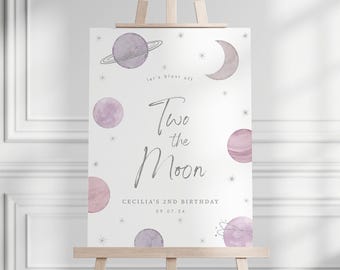 May include: A white rectangular birthday sign featuring watercolor planets and stars in shades of purple and pink. The text reads: let's blast off, Two the Moon, CECILIA'S 2ND BIRTHDAY, and 09.07.24. The sign is displayed on a wooden easel.