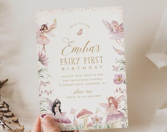 Puede incluir: Una tarjeta de invitación de cumpleaños rectangular con texto dorado que dice Emilia's Fairy First Birthday, August 12th from 12-3pm, The Enchanted Garden, 8 Forest Path, Newport, RI, please rsvp Sofia at 123.456.7890, con ilustraciones de hadas.