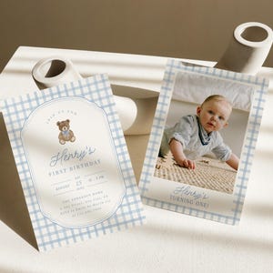 May include: Two rectangular birthday invitation cards featuring a light blue and white gingham pattern. One card displays a teddy bear illustration and text reading Henry's First Birthday, while the other shows a photograph of a child.