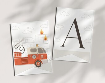 May include: Two rectangular wall art prints. One print features a red and white fire engine with the number 3 on the door, parked in front of a building with flames on the roof. The second print displays a large, bold, black capital letter A.
