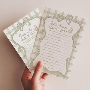 May include: Two rectangular baby shower game cards featuring a sage green plaid background. One card is titled Who Knows MAMA BEST? with a list of eleven questions and a duck illustration. The other card is titled Guess Who MOM OR DAD.