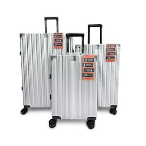 May include: Three silver aluminium suitcases with a vertical ribbed design. Each case has a retractable black handle, black wheels, and a small orange tag. The suitcases are different sizes, suitable for travel.