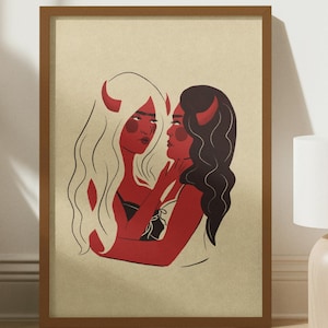 May include: A framed illustration of two women with horns, embracing each other. They are both depicted with red skin and black eyes. The background is a light beige color.
