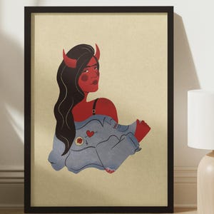 May include: A framed illustration of a woman with red skin and horns, wearing a blue denim jacket with patches. The background is a light beige colour.