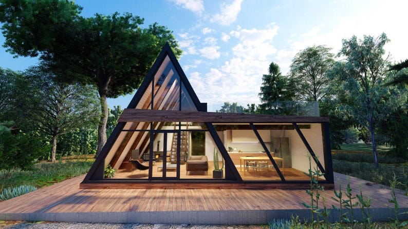 May include: A modern, triangular-shaped house with large windows and a wooden deck. The house is surrounded by trees and greenery.
