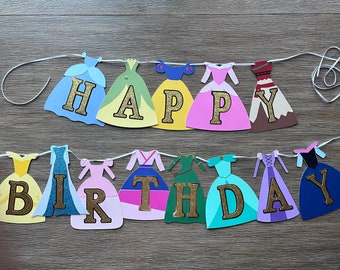 May include: A princess-themed birthday banner with the words "Happy Birthday" spelled out in gold glitter letters. Each letter is decorated with a different princess's dress.
