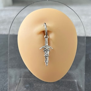 May include: Silver sword charm hanging from a hoop earring. The earring is displayed on a flesh-toned ear model.
