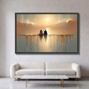 Op de afbeelding: Een rechthoekige wandkunstprint in een zwarte lijst met twee figuren die op een horizonlijn zitten tegen een gouden zonsondergang. Het onderste deel van de afbeelding toont verticale druppels goudkleurige verf die over een grijze achtergrond lopen.