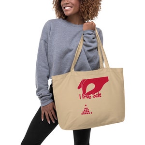 Op de afbeelding: Een beige tote bag met rode handvatten en een rode afbeelding van een hand die zout strooit met de tekst "I Love Salt".