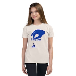 Op de afbeelding: Een wit T-shirt met een blauwe handgrafiek die zout giet. De tekst "I Love Salt" is op het T-shirt gedrukt.